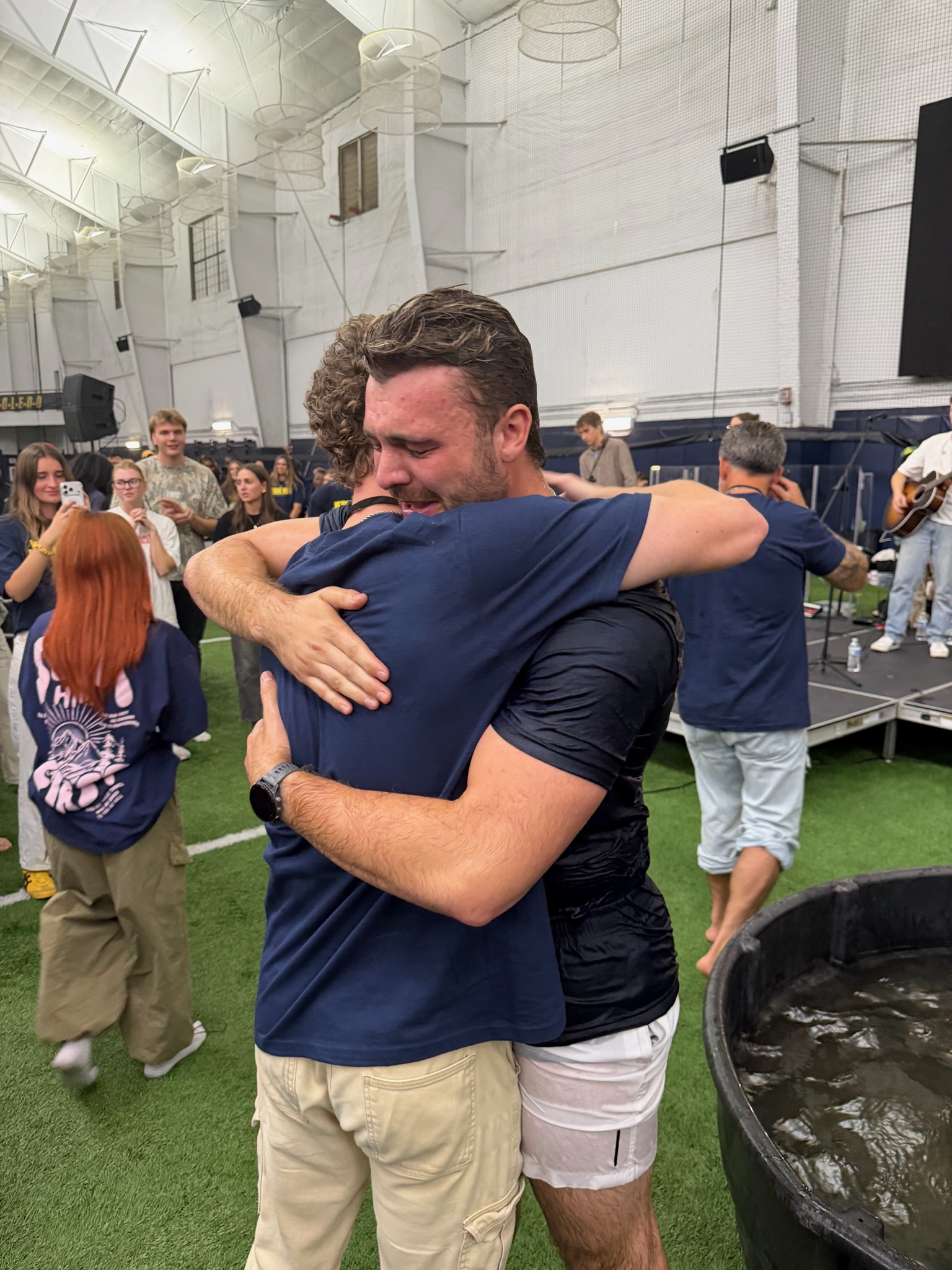 Two men embrace beside the baptism tub at the University of Toledo on September 14, 2026
